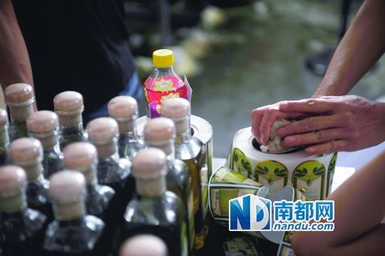 桌上堆著灌好的橄欖油與成卷的標簽貼紙。