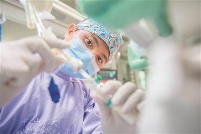 中山大學(xué)孫逸仙紀(jì)念醫(yī)院南院區(qū)重癥醫(yī)學(xué)室，賴永新為患者接腸外營養(yǎng)液，補(bǔ)充能量。