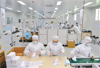 工人在流水線上，將生產好的口罩打包