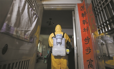 工作人員背著重達15公斤以上的機器，對確診病例屋里物品進行細致消毒。