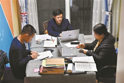 同一張書桌上，孩子做作業，夫婦倆則備課。